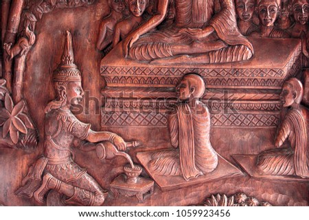 Buddha image carved on a wooden temple in Thailand.