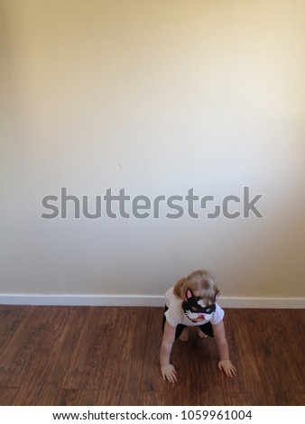 Blond girl plays dress up as cat in empty room