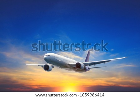 Passenger airplane flying above night clouds and amazing sky at the sunset.  Royalty-Free Stock Photo #1059986414