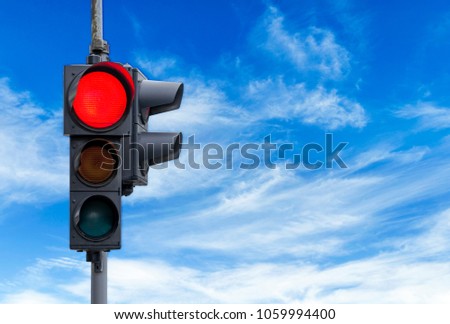 Red semaphore light with cloudy sky background