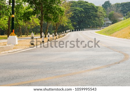 The road has a curved path and green grassy hillsides.