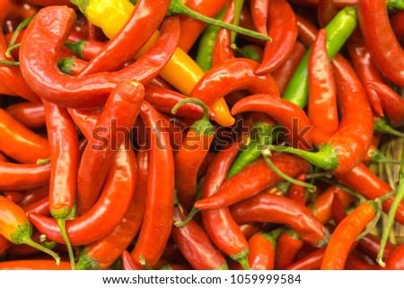 Red, green and yellow chili peppers in a market