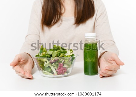 Close up cropped woman at table with green detox smoothies, salad in glass bowl isolated on white background. Proper nutrition, vegetarian food, healthy lifestyle, dieting concept. Area to copy space