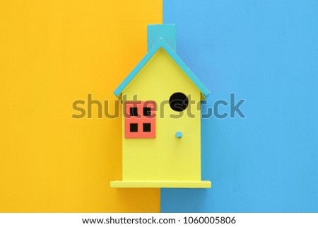 Top view Image of colorful house model over double colorful background. Real estate concept