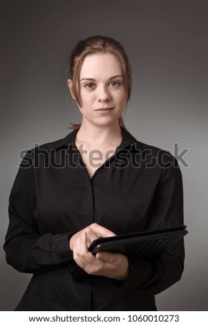 young business woman using a computer shot in the studio on a grey background