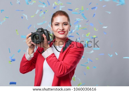 Beautiful happy woman with camera at celebration party with confetti . Birthday or New Year eve celebrating concept