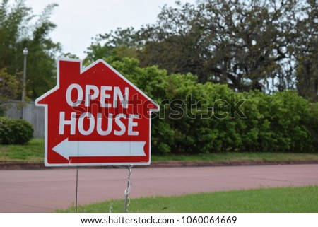 Real estate open house sign on lawn in nice suburban neighborhood.