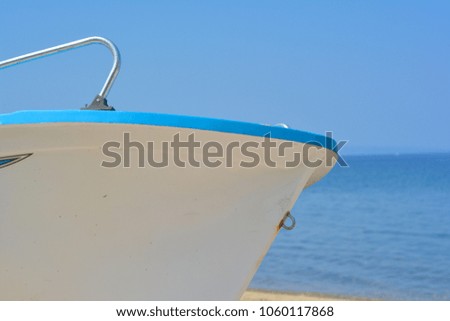 Boat on beach, over blue sky and sea