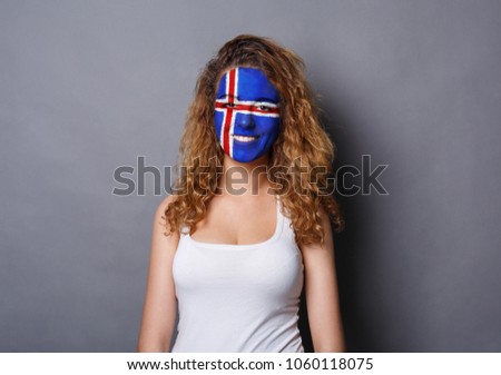 Portrait of a woman with the flag of Iceland painted on her face. Football or soccer team fan, sport event, faceart and patriotism concept. Studio shot at gray background, copy space