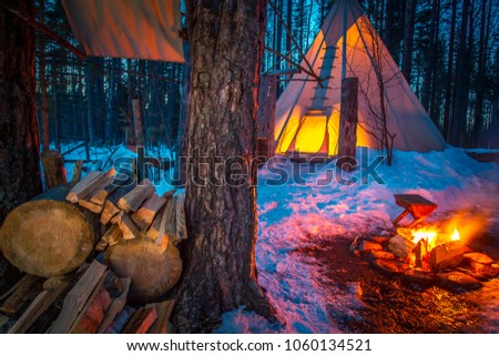 The wigwam in the forest. Burning bonfire against the backdrop of the Wigwam. The home of the Indians of Tipi. National Indian House. Nomadic way of life. The structure of the Tipi nomads.