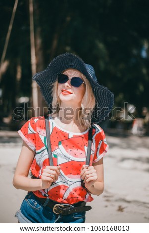 Happy girl posing in the beach with backpack and hat,woman wearing backpack at the sunset beach during the holiday trip at mediterranean sea/ young girl backpacker/ space for your text