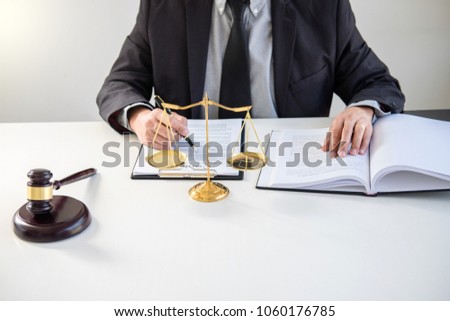Male lawyer or judge working with Law books, gavel, report the case on table in modern office, Law and justice concept.