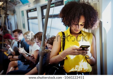 Young woman using a smartphone in the subway Royalty-Free Stock Photo #1060222451