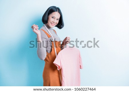 Asian girl designer is showing off the shirt she is designing.