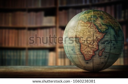 Old globe on bookshelf background. Selective focus. Retro style. Science, education, travel, vintage background. History team.