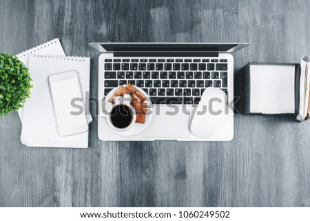 Mix of office supplies, laptop and smartphone on stylish wooden desktop with other items. Above view. Mock up 