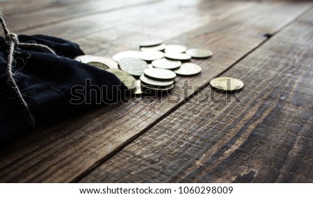 pouch of gold coins on wooden background Royalty-Free Stock Photo #1060298009