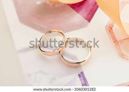 Two white and rose gold wedding rings on pastel background with ribbons. Silver and gold rings. Wedding invitation concept