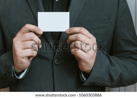 Business man holding white business card.