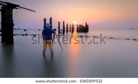 Alone photographer shoots the seascape with old Concrete pier Thailand .