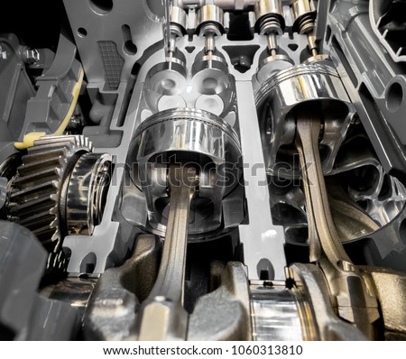 Inside view of modern engine, close up detail of two pistons in cylinder with four valves,some gears aside. Royalty-Free Stock Photo #1060313810