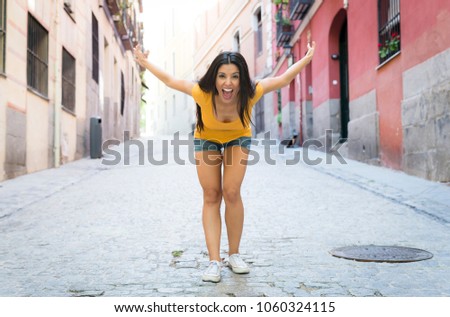 young attractive latin woman happy and excited posing on modern urban European city background in tourism and holiday travel concept 