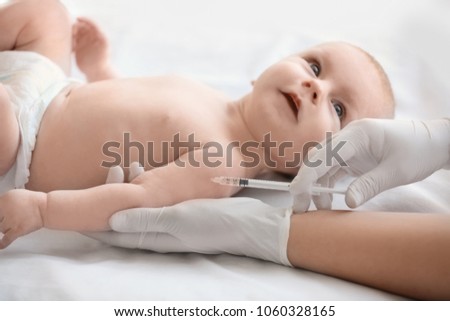 Doctor vaccinating baby in clinic Royalty-Free Stock Photo #1060328165