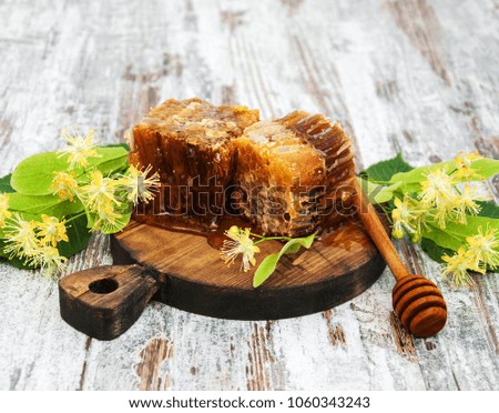 Honey comb and linden flowers on a board