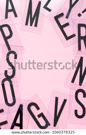 Frame of english letters with copy space on pastel pink background. Alphabet study, abc, education or business concept. Top view. Close-up.