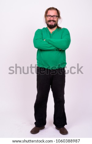 Portrait of bearded man with mustache and long hair wearing green sweater against white background