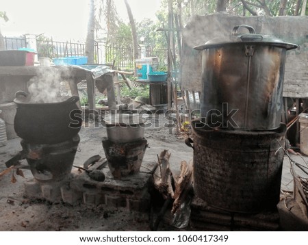 Stainless steel pot with boiling water inside and a lot of water vapor floating in the air.symbolizes the traditional history of Asian cooking.  