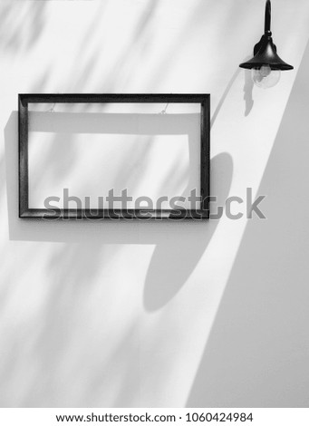Empty wooden frame on the wall with shadow, black and white style
