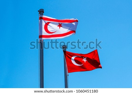 Turkish and North Cyprus flags on blue sky background