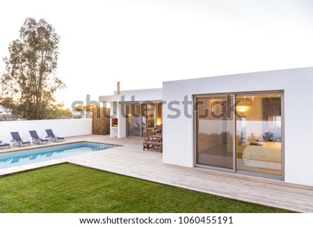 Modern house with garden swimming pool and wooden deck