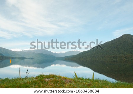 This is a picture of a lake in New Zealand. The lake gave it a comfortable and calm feel, and it can feel a cool feeling thanks to the distant snow.