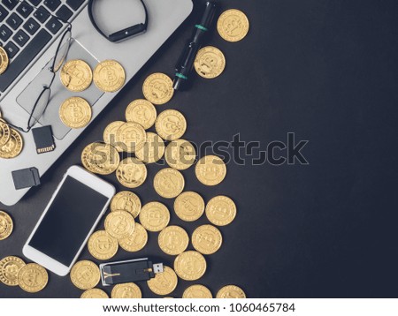 CryptoCurrency concept with stack golden Bitcoins, laptop and smartphone on black background.