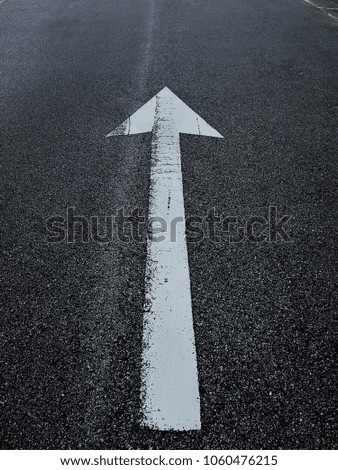 moving forward go straight white  arrow symbol on the asphalt concrete road 
