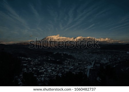 aerial shot of the Albania city Berat with a big mountain in the back at the sun rise