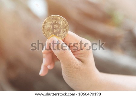 closeup image of woman holding golden coin bitcoin in hand - electronic virtual money for web banking and international network payment : selective focus