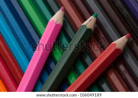 Red, green and pink color pencils on a color set