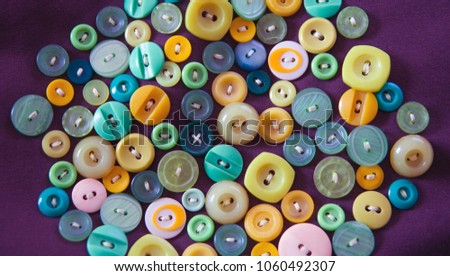 old , colorful and different shapes buttons, sewn to the pillow. top view, flat lay.
