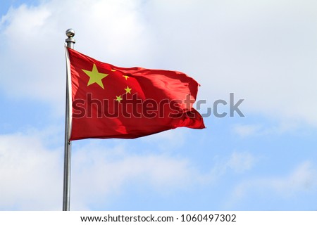 Chinese flag waving in the wind on a sunny day Royalty-Free Stock Photo #1060497302