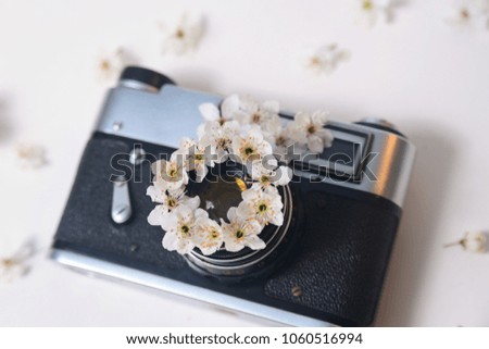 Old retro camera with spring flowers on a white background, top view, picture and art concept