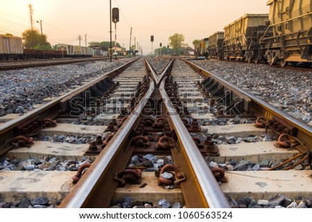 Railway Tracks Merge in Local Train Station Landscape on Sunset