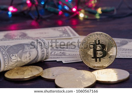 Dollar banknotes and Bitcoins on a dark wooden table