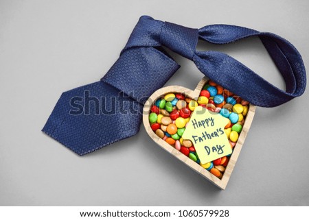 home with necktie and wooden heart with many colorful candies in happy father's day. male blue tie