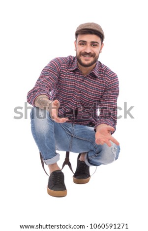Handsome young man wearing a classic outfit and sitting on the floor  isolated on white background