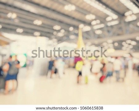 Abstract blurred image background of group people or arriving passengers with their suitcases holding luggage walking in international  airport terminal, travelling or business concept. vintage tone.