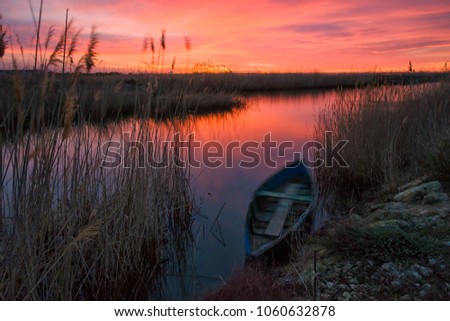 Long exposure phography: Movement of a boat at dramatic sunrise within Delta del Ebro 