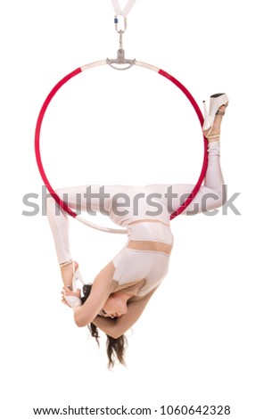 A young girl performs the acrobatic elements in the air ring. Studio shooting performances on a white background.